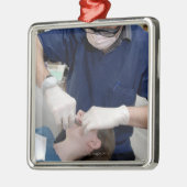 aの歯科支柱を再調整している歯科矯正医 メタルオーナメント (左)