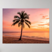 A palm tree stands alone on the beach at sunset ポスター (正面)
