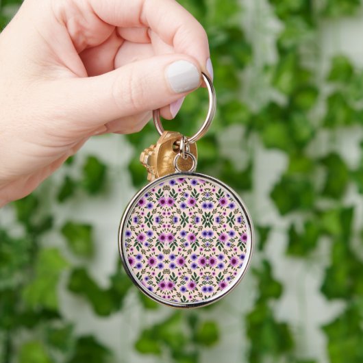 A round keychain features a detailed floral キーホルダー (手)