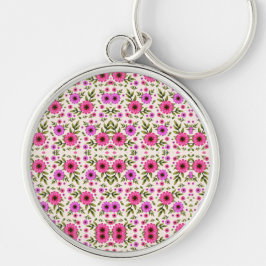 A round keychain featuring a colorful floral  キーホルダー
