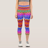 A woman wears vibrant, zigzag-patterned leggings  カプリレギンス (正面)