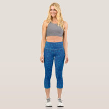 A woman's torso and legs in blue capri leggings 