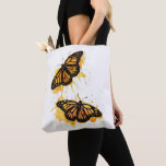 Artistic Watercolor Monarch Butterfly Nature Art トートバッグ<br><div class="desc">The design features two vibrant monarch butterflies in mid-flight, rendered with artistic paint splatters in warm shades of orange and yellow. This nature-inspired graphic captures the delicate elegance of spring wildlife. It makes a wonderful gift for gardeners, entomology enthusiasts, nature lovers, or anyone who appreciates the symbolism of freedom and...</div>