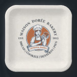 Bakery Store Pastry Chef Dessert Sweets Cake Baker ペーパープレート<br><div class="desc">This vintage-style circular logo features a cheerful female pastry chef wearing a traditional white chef's hat and apron. She is framed by a warm orange circular backdrop and holds a wire whisk in one hand and a flaky croissant in the other, symbolizing her culinary expertise. Below her, a blank, elegant...</div>