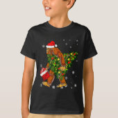Bigfoot Carrying Christmas Tree Sasquatch Believer Tシャツ (正面)