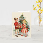 Boy and girl giving each other Christmas presents カード (黄色い花)