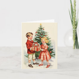 Boy and girl giving each other Christmas presents カード