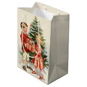Boy and girl giving each other Christmas presents ミディアムペーパーバッグ (裏面アングル)