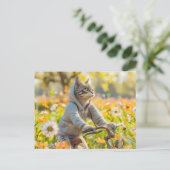 Cat in hoodie cycling across summer meadow シーズンポストカード (スタンド正面)