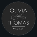Chic Modern Minimalist Typography Black Wedding ラウンドシール<br><div class="desc">Minimalist black wedding seals place the couple’s names front and center — boldly presented and elegantly connected by a calligraphic “and” that adds a graceful,  romantic flourish.

Fully customizable to reflect your unique style — with adjustable text and background colors to perfectly complement your wedding aesthetic.</div>