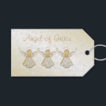 Christmas Angel of Grace金ゴールド/ホワイト「宛先：自：」 ギフトタグ<br><div class="desc">必要に応じて、前面の文字を提供された文字テンプレートでカスタマイズする。これは金ゴールドのフィリーグリーと開いた翼を持つグレースのクリスマスエンジェルのグラフィックデザイン。彼女は「恵み」という言葉で額を掲げている。背景は黄金と雪グラデーション片で覆われる。背中には文字「To:」と「From:」があり、ハンドネーム用のスペースが書ある。これはエレガント、あなたの特別な贈り物ラベルのためのアイディアは、この休日の家やオフィス。</div>