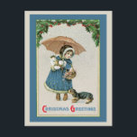 Christmas Postcard:  Vintage Christmas Postcard シーズンポストカード<br><div class="desc">Vintage Christmas Postcard This adorable old time Christmas card image features a girl holding an umbrella in one hand and cuddling a kitten or kitty cat, while a small dog or ouppy pulls at her winter coat. She is also carrying a basket filled with flowers and standing under an arc...</div>