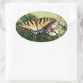 Cleomeの隣のタイガーアゲハチョウのクローズアップ 楕円形シール (バッグ)