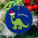 Cute Christmas Dinosaur Custom Kids Blue セラミックオーナメント<br><div class="desc">Awesome green dinosaur smiling and looking very cute in a holiday red Santa Claus hat. Customize this adorable children's Christmas ornament gift with the recipient's name to make it even more personalized. Cool little boy present for a kid.</div>