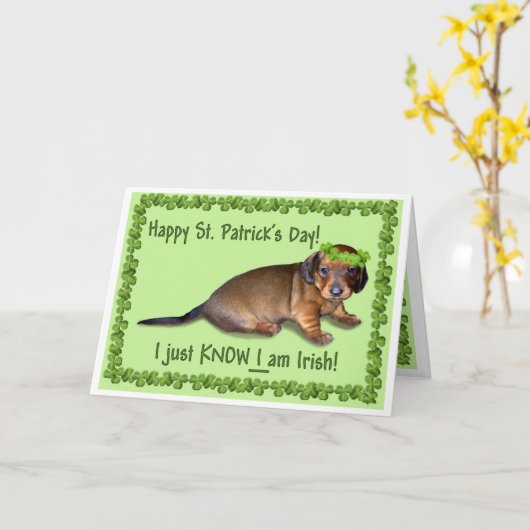 Doxieの混同した子犬からの幸せなセントパトリックの日 カード (黄色い花)