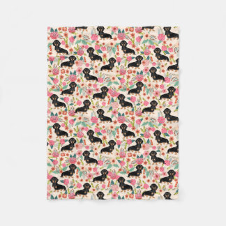 Doxieは-黒および黄褐色のダックスフント-クリームの一面をおおいます フリースブランケット