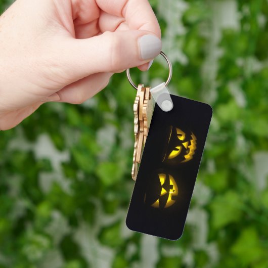 Eerie yellow glow pumpkin faces on black long キーホルダー (手)