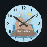 Funny happy walrus cartoon illustration ラウンド壁時計<br><div class="desc">Our happy walrus is sitting,  sunning himself on a rock in the ocean. Lots of fun for a walrus day in cartoon style!</div>