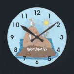 Funny happy walrus cartoon illustration ラウンド壁時計<br><div class="desc">Our happy walrus is sitting,  sunning himself on a rock in the ocean. Lots of fun for a walrus day in cartoon style!</div>