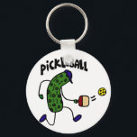 Funny Pickle Playing Pickleball キーホルダー<br><div class="desc">Wonderful artistic funny pickle wearing a blue cap and playing pickleball design makes a fun unique gift.  Can also add custom text and change background color when ordering.</div>