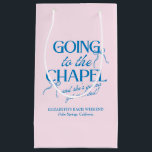 Going to the Chapel Bachelorette Weekend スモールペーパーバッグ<br><div class="desc">The Going to the Chapel Bachelorette Collection blends playful charm with classic bridal style. Featuring a soft pink background paired with bold blue typography, this suite captures the excitement of a bride-to-be heading down the aisle. Delicate bow illustrations and a mix of elegant serif and flowing script fonts add a...</div>