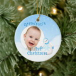 Grandson's 1st Christmas Snowman セラミックオーナメント<br><div class="desc">Your grandson will cherish his 1st christmas snowman ornament with his photo. This adorable showman is decked out in fuzzy blue hat, scarf and mittens as delicate snowflakes fall through the winter sky. Add photo to front and name and year to the back of the ornament using the template provided....</div>