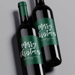 Green and White Brush Script Merry Christmas ワインラベル<br><div class="desc">Festive holiday wine labels featuring "Merry Christmas" displayed in white brush script lettering with a green background. Personalize the Merry Christmas wine labels with your family name and the year displayed in white lettering.</div>