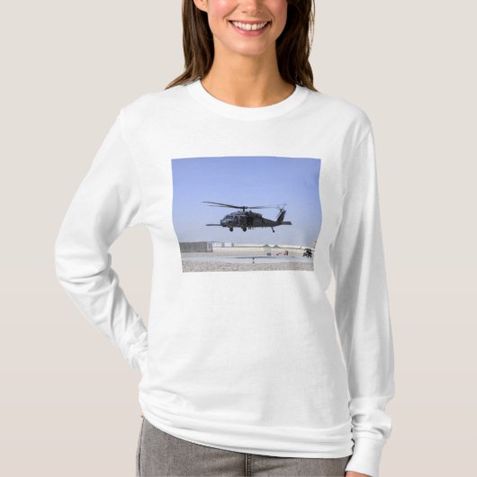 HH-60Gはキャンプバスティオからホークを離陸させる Tシャツ (正面)