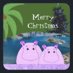 Hippos Ready for Christmas Squareステッカー スクエアシール<br><div class="desc">青い水の中に座って、この2つの可愛いカバを愛する必要がある。ヤシの木、背景にクリスマスツリー。彼ら縁どの下に紫の輝きが見える。</div>