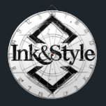 Ink&Style ダーツボード<br><div class="desc">¡Sé el primero en tenerlo! Presentamos la primera obra oficial de Ink&Style: un diseño único que combina elegancia, trazos artísticos y geometría con carácter. Esta pieza es más que un logo: es una declaración de estilo, creatividad e identidad visual. Ideal para cuadros decorativos, rompecabezas, bolsos, posters o cualquier objeto con...</div>