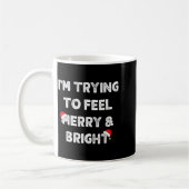 Merry & Bright And I'm Trying To Feel Merry &a コーヒーマグカップ (左)