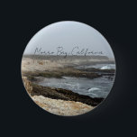 Morro Bay California Coastal Photography 缶バッジ<br><div class="desc">A foggy overcast day in Morro Bay California with the ocean waves hitting the rocks on the shore in this beach photograph souvenir. This seaside travel photo keepsake button features black cursive script above the beach rocks and grey sky.</div>