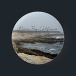 Morro Bay California Coastal Photography 缶バッジ<br><div class="desc">A foggy overcast day in Morro Bay California with the ocean waves hitting the rocks on the shore in this beach photograph souvenir. This seaside travel photo keepsake button features black cursive script above the beach rocks and grey sky.</div>