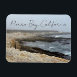 Morro Bay California Ocean Cliffs Photography マグネット<br><div class="desc">A foggy overcast day in Morro Bay California with the ocean waves hitting the rocks on the shore in this beach photograph souvenir. This seaside travel photo keepsake magnet gift features black cursive script above the beach rocks and grey sky.</div>