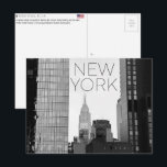 New York, USA Travel Postcard ポストカード<br><div class="desc">Send this beautiful postcard to your loved ones featuring a vertical urban composition framing the Empire State Building and the New Yorker Hotel through a narrow gap between modern skyscrapers.</div>
