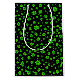 Pattern of green shamrocks on black background ミディアムペーパーバッグ