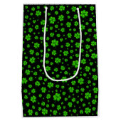 Pattern of green shamrocks on black background ミディアムペーパーバッグ (裏面)