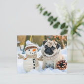 Pug Sitting Next to Snowman in Winter ポストカード (スタンド正面)