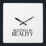 Rooted In Reality Minimalist Typewriter  スクエア壁時計<br><div class="desc">Own the present moment. This modern wall clock features sharp typewriter numerals and a central message reminding you to stay anchored in the here and now.</div>