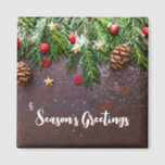 Rustic Christmas Table with Pine & Snow マグネット<br><div class="desc">Magnet with a rustic photograph of a brown wooden table with pinecones,  pine needles,  snow,  and Christmas ornaments. Festive and lovely.</div>