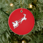 Santa Claus riding sly with reindeer セラミックオーナメント<br><div class="desc">Red and white Santa Claus with reindeer silhouette pattern.</div>