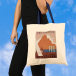 See America Welcome to Montana, Vintage Travel トートバッグ<br><div class="desc">ヴィンテージイラストレーションアメリカ合衆国アメリカ合衆国モンタナからの旅行ポスターは、先住民アメリカインディアンのテエペ、山、湖、木々を特集。文字読：アメリカ、ようこそモンタナ、州旅行局統一された。</div>