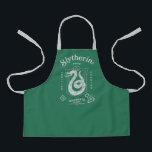 SLYTHERIN™ Pride Ambition Cunning Crest エプロン<br><div class="desc">Show your house pride with this bold Slytherin™ crest design, honoring the ambition and cunning that define this iconic Hogwarts™ house. Featuring the striking serpent coiled within a classic shield, the artwork highlights Slytherin’s core traits — Ambition, Pride, and Cunning — in a clean, vintage-inspired layout. Rendered in signature house...</div>