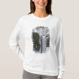 Snowyの森林によって囲まれるぼやけた滝 Tシャツ