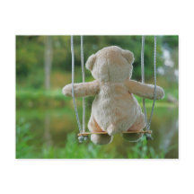 Teddy beertje dat op een schommel zit in de natuur