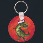 TRex Dino in Santa Hat on Red キーホルダー<br><div class="desc">Animal Parade Tyrannosaurus Rex in Santa Hat on Red features our cute T-Rex wearing a red Santa hat with a textured red background. Our original dinosaur art was painted by our talented children’s illustrator Traci Van Wagoner. On many of our fun holiday gifts and accessories you’ll find our cute T-Rex...</div>