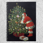 Vintage Christmas, Santa Claus with Presents ノートブック<br><div class="desc">Vintage illustration Merry Christmas holiday design featuring a jolly Santa Claus lighting candles on a decorated Christmas tree with wrapped gifts and presents underneath. Season's Greetings and Happy Holidays!!  Ho,  ho,  ho!</div>